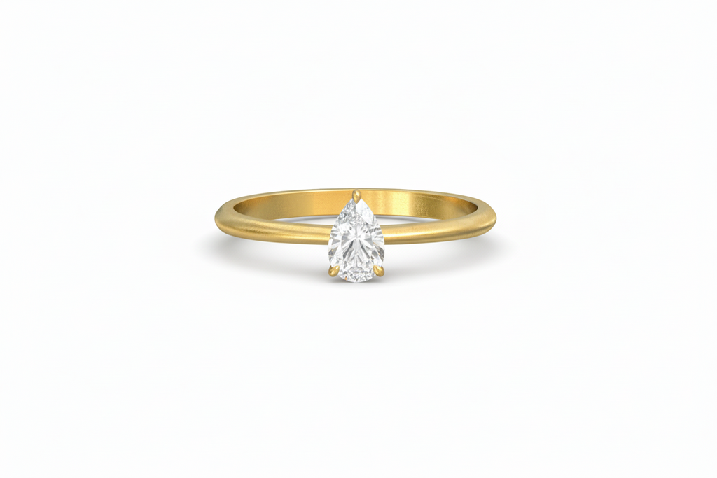 Gold ring with a pear-shaped diamond on a white background
