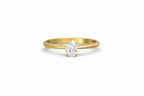 Gold ring with a pear-shaped diamond on a white background