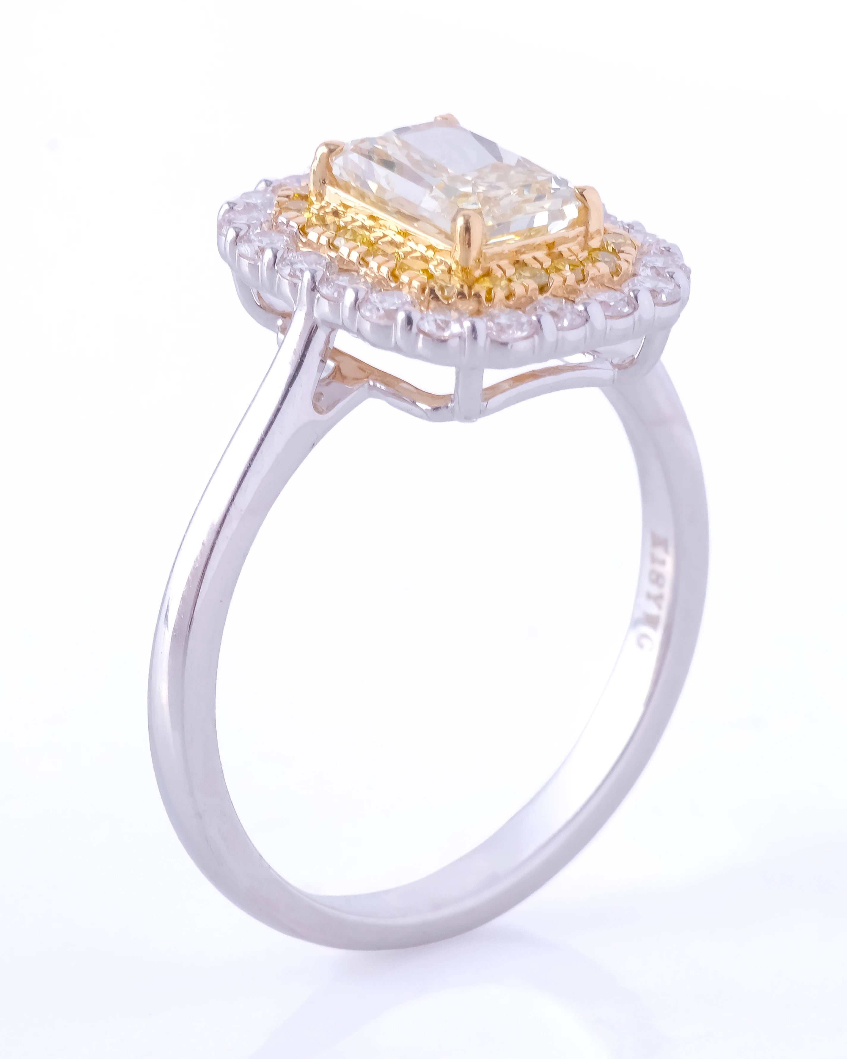 Ring with a yellow gemstone and diamond-studded halo on a white background